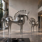 Silver horse sculptures in a modern interior setting