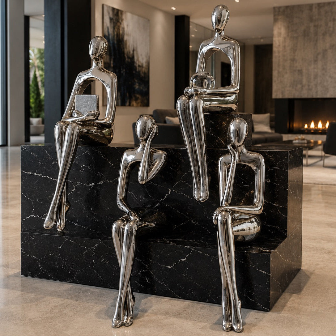 Set of silver abstract sculptures on a black marble base in a modern interior setting.
