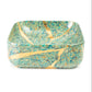 A square ceramic bowl with rounded corners, decorated with a turquoise and teal marbled pattern and accented by gold kintsugi-style cracks, shown on a plain white background.